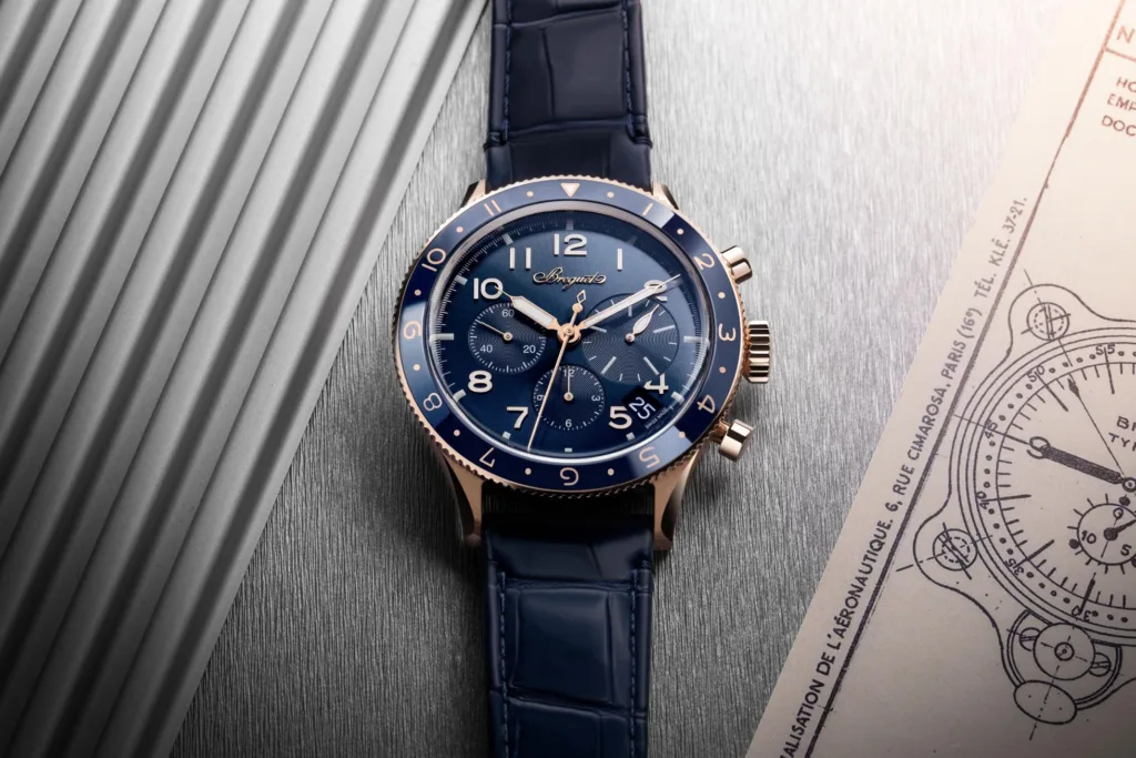 Gold & blue Breguet Type 20 wristwatch in moody setting against aviation-inspired background