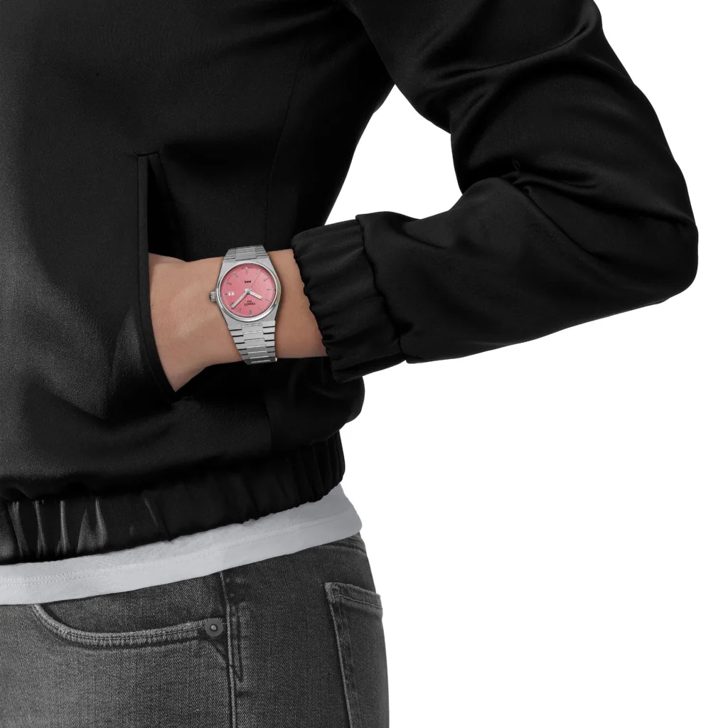 Tissot PRX watch with pink dial worn on the wrist of model