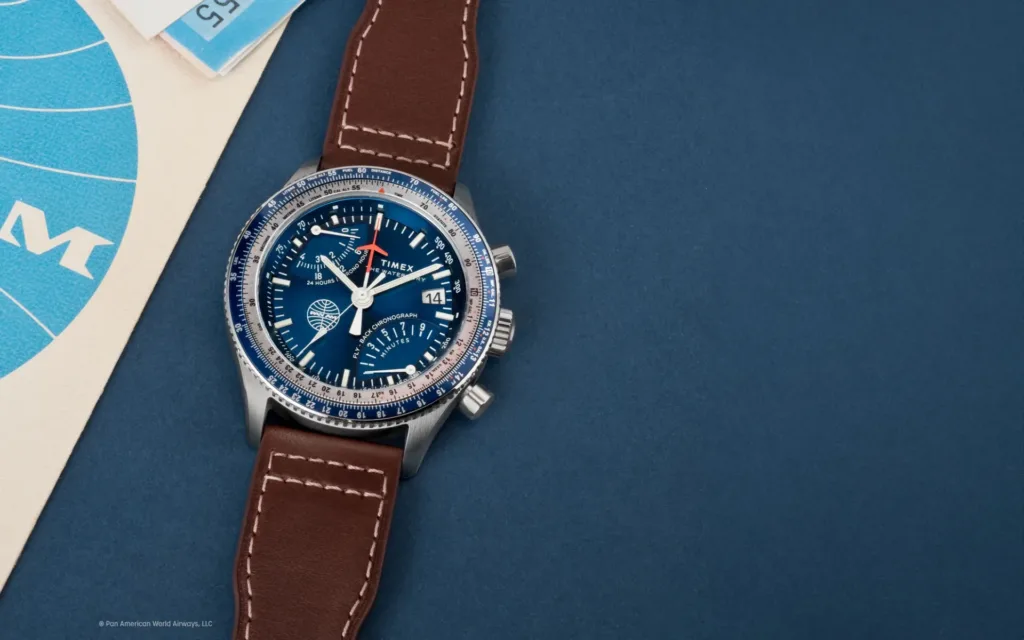 Timex Fly Back Chronograph x Pan Am (Reference TW2W97200) on blue background besides vintage Pan Am papers